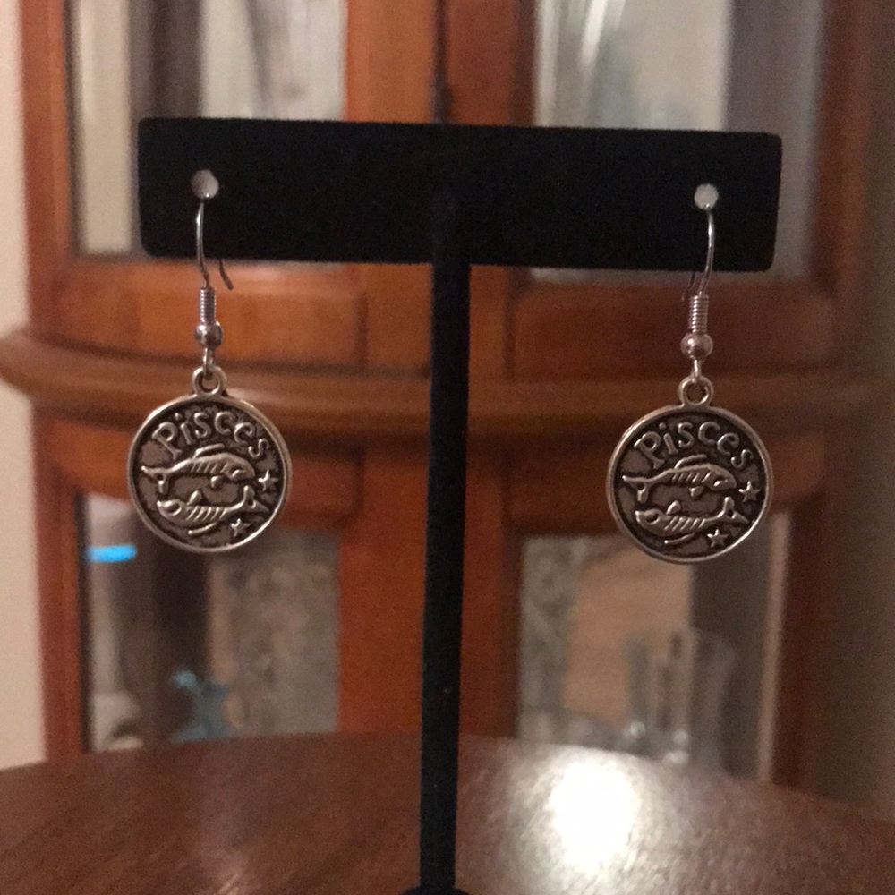 Silver tone PISCES earrings.